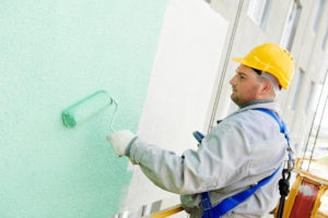 Construction worker painting building facade
