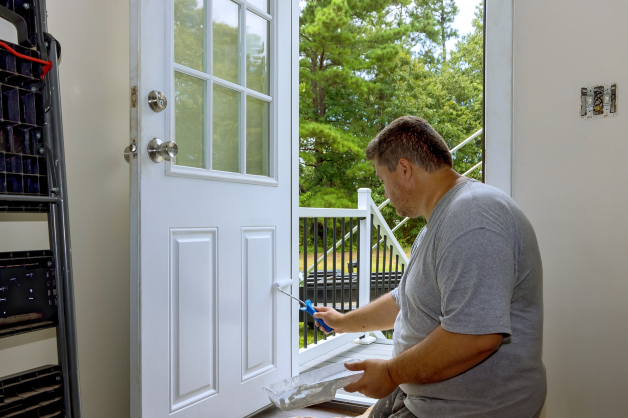 In process of renovating home, worker painted front door with a paintbrush