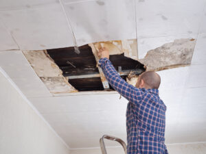 Man repairing collapsed ceiling.